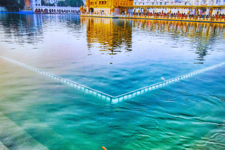 lose-up view of the Golden Temple reflecting in the holy sarovar pool.