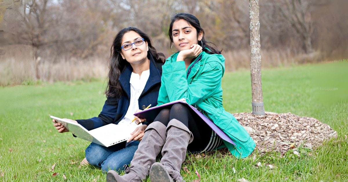 A hopeful image of an Indian family in the U.S. outside a suburban house, symbolizing the dream of permanent residency.